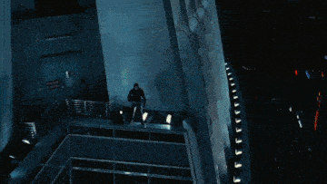 a man is standing on the edge of a building with a sign that says ' emergency exit '