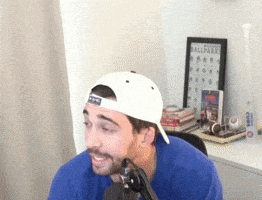 a man wearing a blue shirt and a white hat is smiling