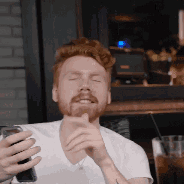 a man with red hair and a beard holds a can of coke