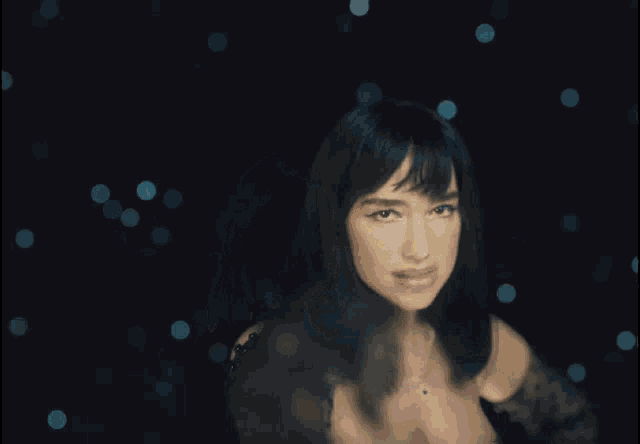 a woman in a black dress and gloves is covering her face