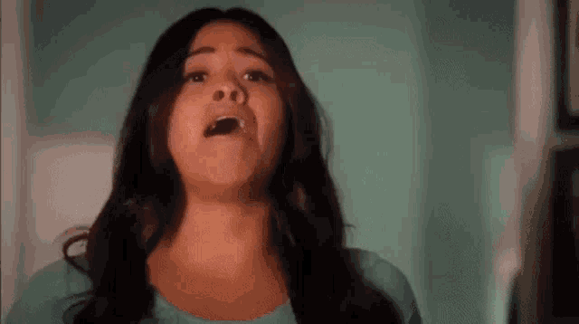 a close up of a woman making a funny face with her mouth open .