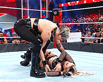 two women are wrestling in a wrestling ring with a sign that says ' i love you ' on it