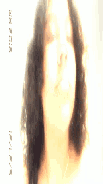 a woman 's face is shown with a digital clock displaying the time as 9:03 am