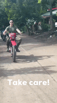 a man riding a red motorcycle on a dirt road with the words take care on the bottom