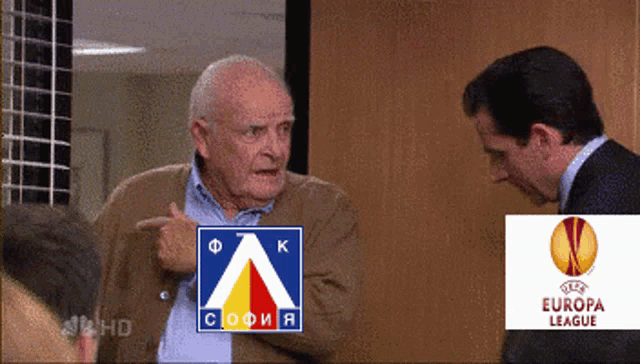a man points at a sign that says europa league on it