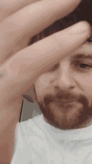 a man with a beard is wearing a white shirt