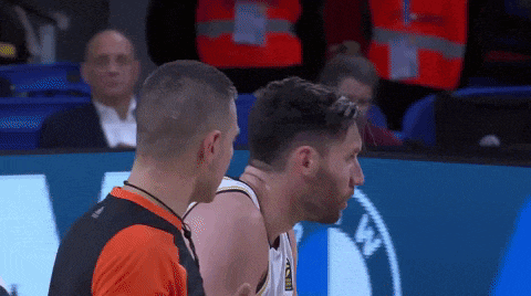 two basketball players are talking to each other and one of them has the word bmw on his shirt