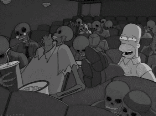 a group of skeletons are sitting in a movie theater watching a movie .