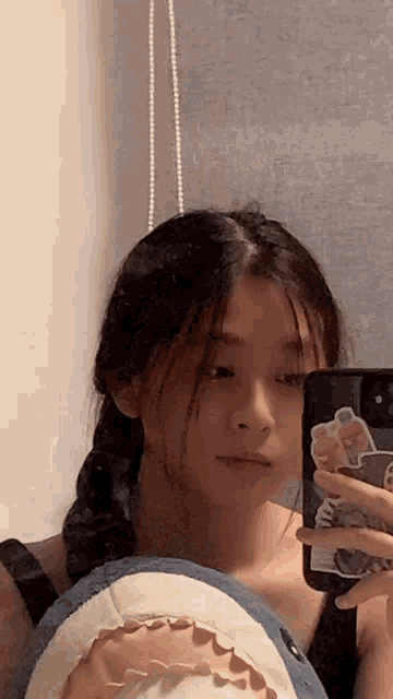 a girl is taking a selfie in front of a mirror with a stuffed shark .