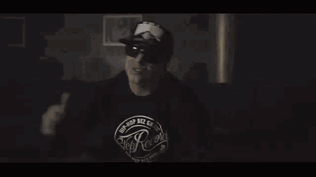 a black and white photo of a man wearing a patriots hat