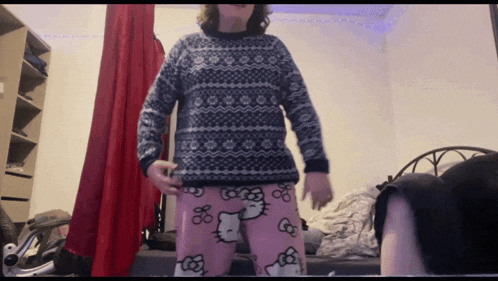 a person wearing a hello kitty sweater and pink pajamas