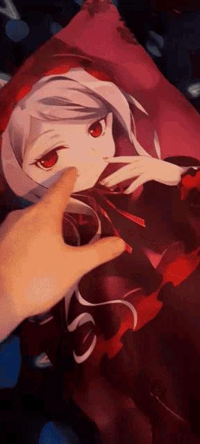 a person 's hand is pointing at a picture of a girl with red eyes