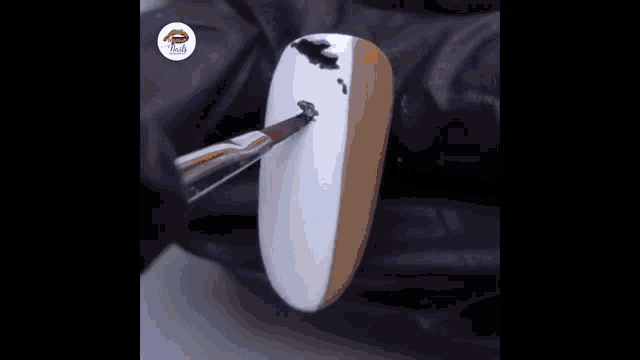 a close up of a nail with black and white cow print