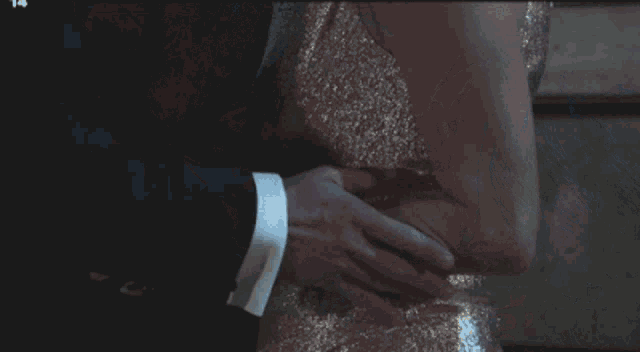 a man in a suit and tie kisses a woman in a wedding dress with a flower in her hair