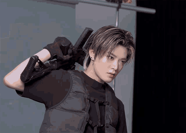a young man with a gun on his shoulder