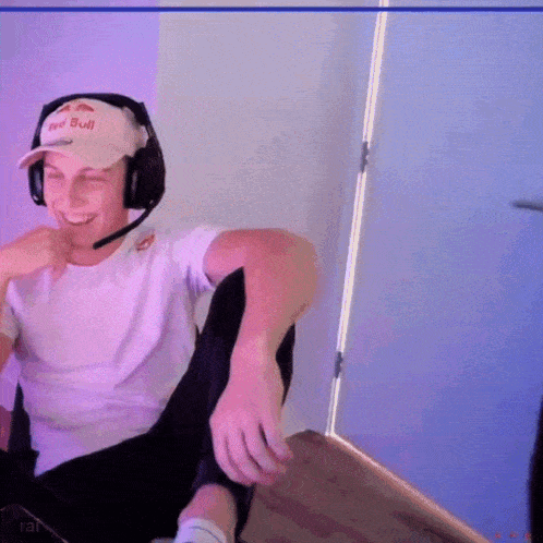 a man wearing headphones and a hat that says red bull