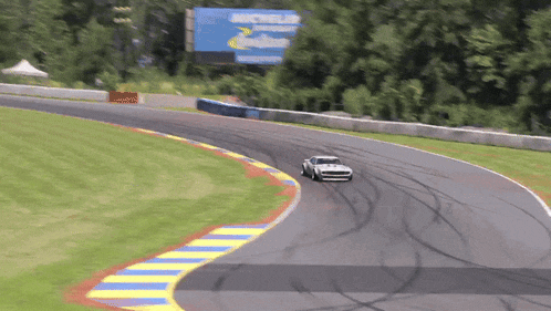 a car is driving down a race track with a michelin sign in the background