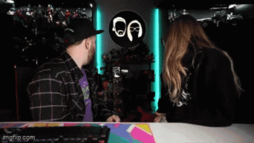 a man and a woman are talking in front of a sign that says oa on it