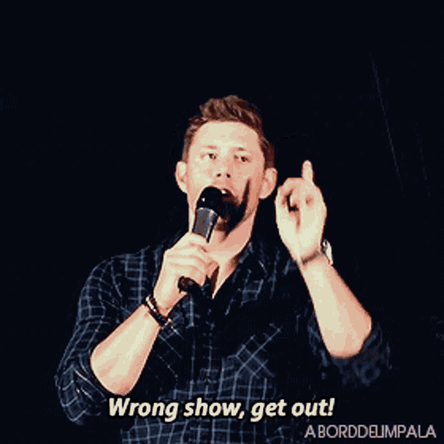 a man speaking into a microphone with the words wrong show get out