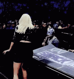 a blonde woman in a black dress is standing in front of a crowd