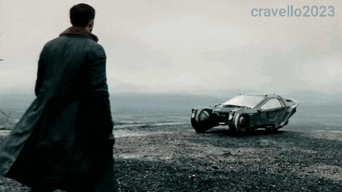 a man in a trench coat stands in front of a futuristic car with the year 2023 on the bottom
