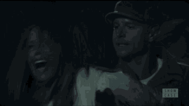 a man is holding a woman in a dark room with the words show case on the bottom