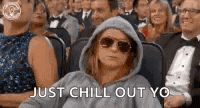 a woman in a hoodie is sitting in a crowd of people .