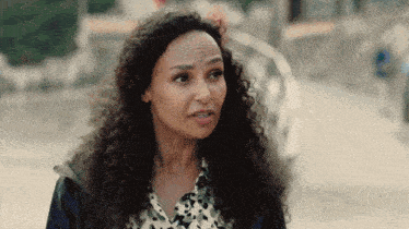 a woman with curly hair and a leopard print shirt