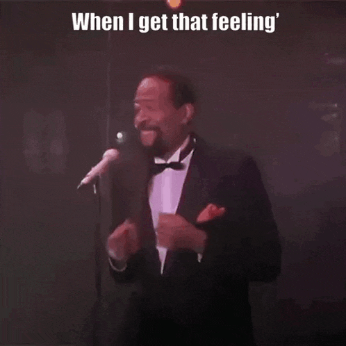 a man in a tuxedo singing into a microphone with the caption when i get that feeling
