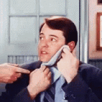 a man in a suit and tie is getting his tie adjusted by another man .