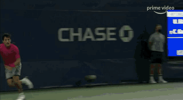 a man stretches on a tennis court in front of a scoreboard that says rolex