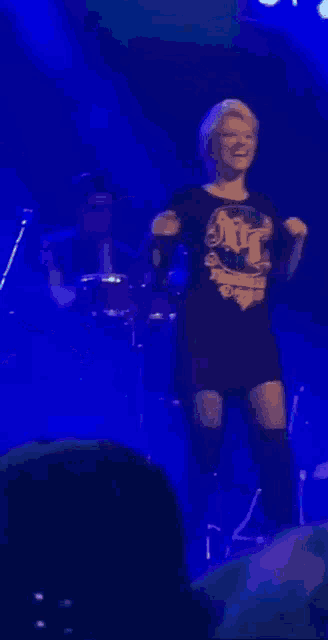a woman is singing into a microphone on stage .