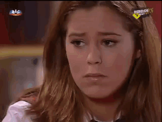 a close up of a woman 's face with a rebelde way logo on her headband
