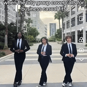 three men in suits and ties are walking down a street .