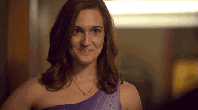 a woman in a purple one shoulder dress is making a face