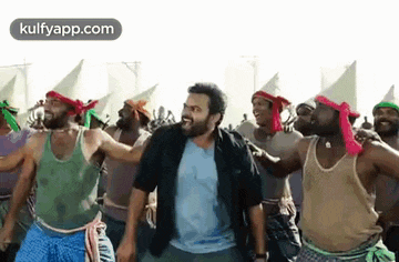 a man is dancing in front of a crowd of people wearing cones .