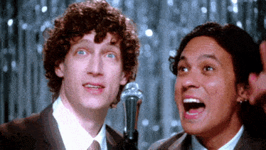 two men standing next to each other with their mouths open