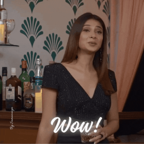 a woman in a black dress is holding a glass of whiskey and the word wow is above her