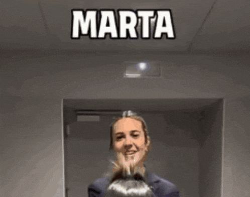 a woman in a suit is standing in a hallway with the words " indignada x3 " above her