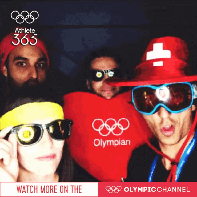 a group of people posing for a picture with the olympian logo on their shirts