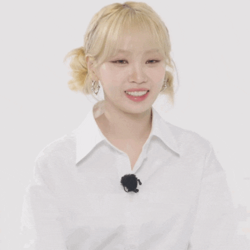 a woman wearing a white shirt with a black microphone on her neck