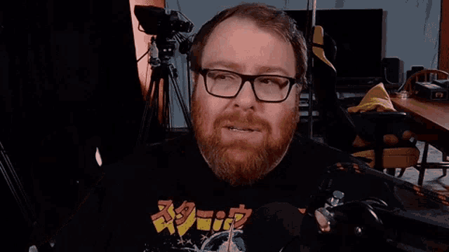a man with glasses is making a surprised face next to another man with a beard