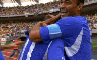 a man in a blue shirt is hugging another man in a blue shirt
