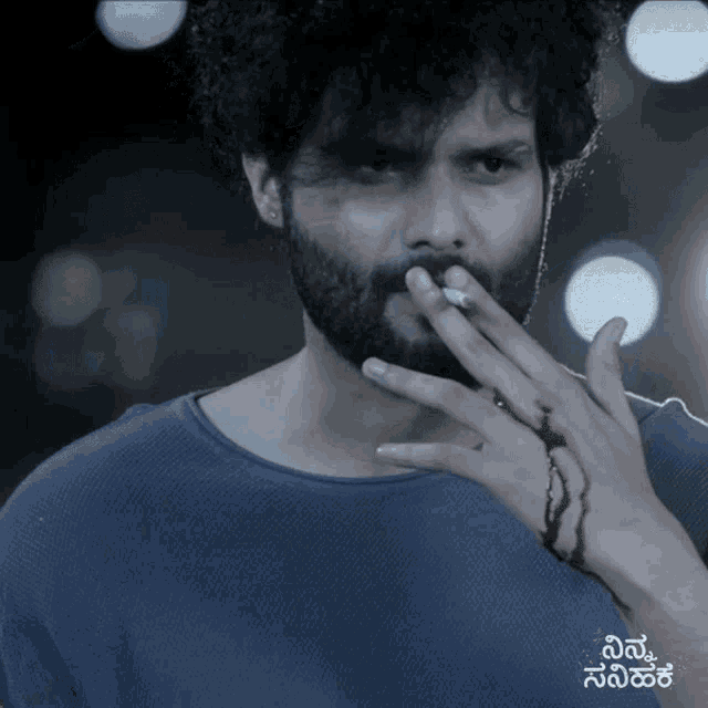 a man with a beard is smoking a cigarette and his hand is bloody