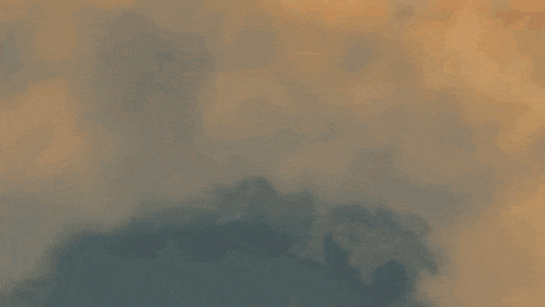a sunset with a lot of clouds and smoke coming out of them