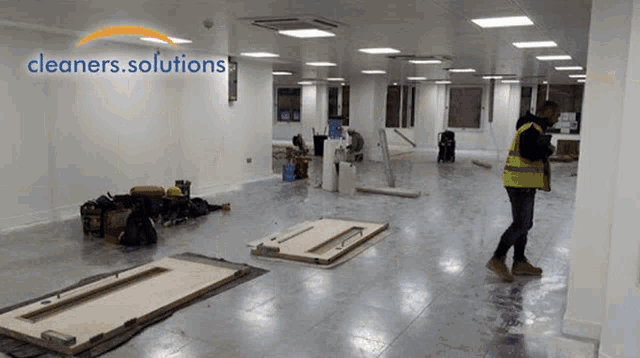 a man standing in an empty room with cleaners.solutions written on the top