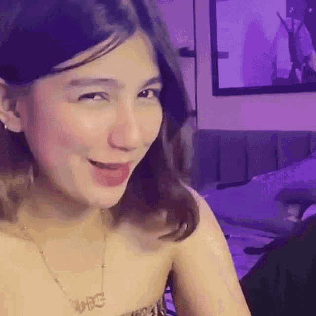 a woman is making a funny face while sitting on a bed in a living room .