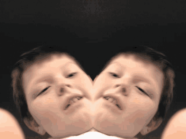 a close up of a child 's face with a reflection of another child 's face