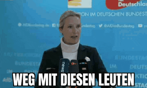 a woman is giving a speech in front of a microphone and says weg mit diesen leuten .