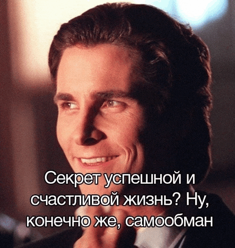 a man in a suit is smiling with a foreign language caption behind him
